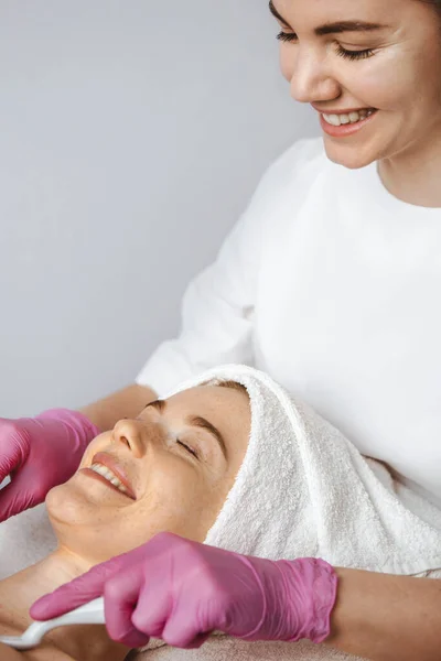 Freckled caucasian woman with closed eyes receiving chest massage with porcelain spoons in beauty spa salon. Medical healthcare. Beauty woman body. Health care