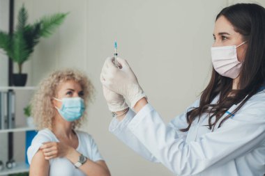 Doctor in laboratory holding a syringe with liquid vaccines for patients. Concept: diseases, medical care, science. Vaccination, immunization, disease