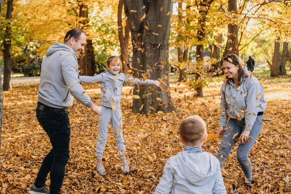 Young Family Four Members Rejoicing Forest Throwing Leaves Air Autumns — Stok fotoğraf