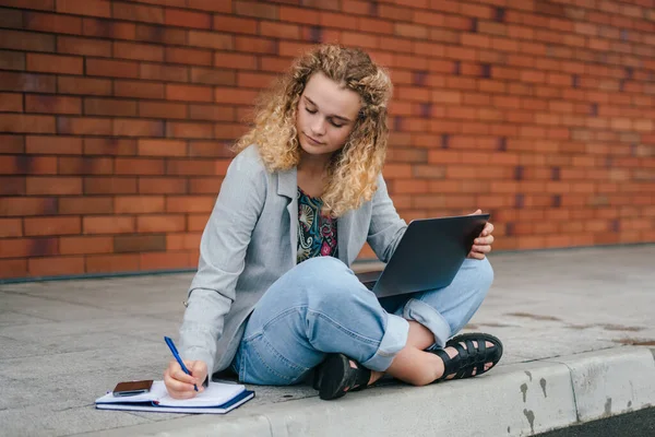 Allvarlig Koncentrerad Lockig Kvinna Student Med Bärbar Dator Skriva Anteckningar — Stockfoto