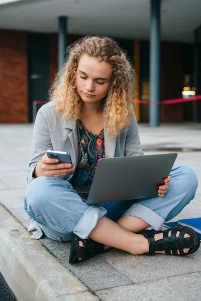 Mladá Běloška Studentka Sedí Poblíž Univerzity Laptopem Používá Smartphone Surfování — Stock fotografie