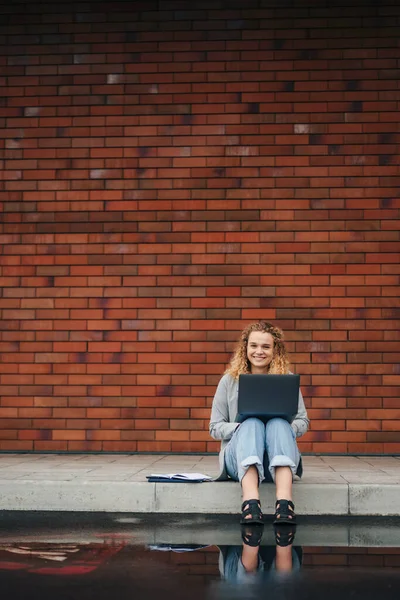 Ευτυχισμένη Νεαρή Σγουρή Γυναίκα Φοιτητής Δακτυλογράφηση Φορητό Υπολογιστή Κάθεται Εξωτερικούς — Φωτογραφία Αρχείου
