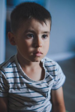 Kafkasyalı bir çocuğun portresi, kanepede oturmuş, derin düşüncelere dalmış, hafta sonları evde dinlenirken. Bir çocuğun duyguları, karantina...