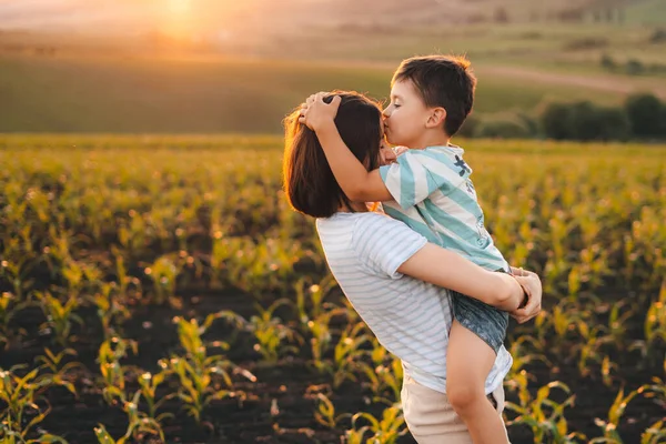 Ευτυχισμένο Αγόρι Φιλάει Μητέρα Του Στο Μέτωπο Στέκεται Στο Χωράφι — Φωτογραφία Αρχείου