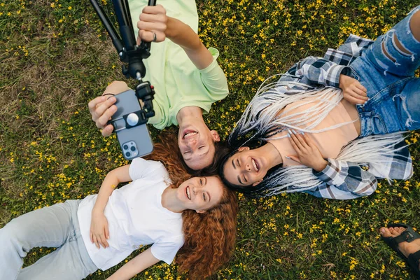 Three Beautiful Teenagers Using Telephone Device Take Selfie Lying Grass — Stock Photo, Image