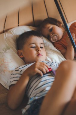 İki çocuk yastıklarla yerde uzanıyor, şemsiyenin altında dinleniyorlar, içeride. Mutlu bir aile. Eğlenceli aile..