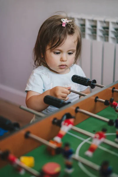 Curious Baby Girl Standing Football Table Watching Her Family Play — Stock Photo, Image
