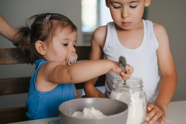 两个快乐的小孩在家里的现代厨房里准备松饼 称着他们的菜谱需要多少面粉 有趣的家庭 — 图库照片