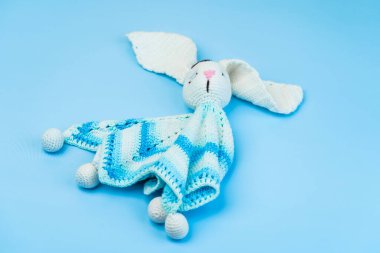 Mavi arka planda izole edilmiş bebekler için el yapımı mavi-beyaz oyuncak kumaş iplikleri..