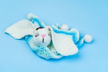 Mavi arka planda izole edilmiş bebekler için el yapımı mavi-beyaz oyuncak kumaş iplikleri..