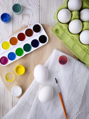 Paskalya resmi. Paskalya eğlencesi ve tatlı yumurtalar. Renkli palet ve fırça. El yapımı Paskalya sanatı. El işi. Çocuk sanatı. Mutlu yumurta ve yüz.. 