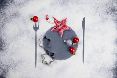 Noel ve yeni yıl sofrası. Kurabiyeler, yıldızlar ve balolarla süsleme. Çatal, tabak ve bıçak desenli beyaz bir zemin. Noel desenli dekorasyon. Noel Estetiği