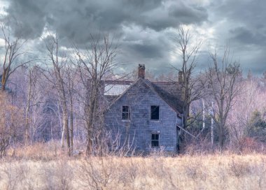 Baharda terk edilmiş ürkütücü bir ev Kanada kırsalındaki bir çiftlik avlusunda.