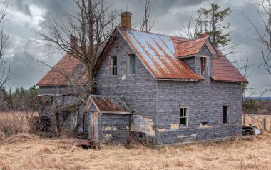 Baharda terk edilmiş ürkütücü bir ev Kanada kırsalındaki bir çiftlik avlusunda.
