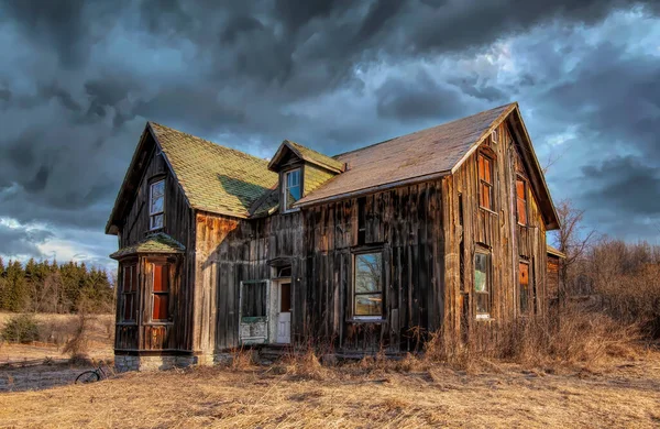 Kışın Kanada 'nın kırsal kesimindeki bir çiftlik bahçesinde terk edilmiş ürkütücü bir ev.