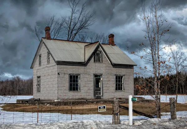 Kışın Kanada 'nın kırsal kesimindeki bir çiftlik bahçesinde terk edilmiş ürkütücü bir ev.