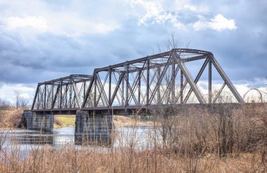 Old iron railway truss bridge built in 1893 crossing the Mississippi river in spring in Galetta, Ontario, Canada