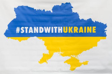 RIGA, LATVIA. 17 Şubat 2022. Seçici odak fotoğrafı. Riga 'daki Özgürlük Anıtı yakınlarındaki pankartta Ukrayna sloganı ve Ukrayna haritasıyla dur.