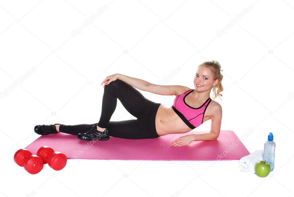 Slender young woman doing sports on the mat