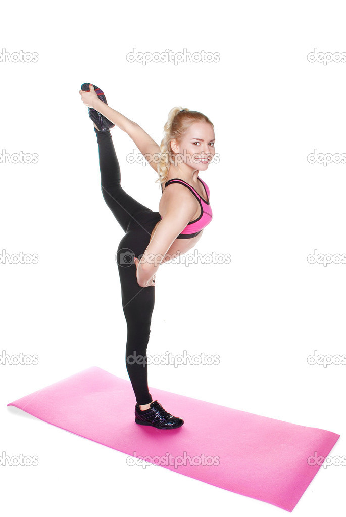 Slender young woman doing sports on the mat