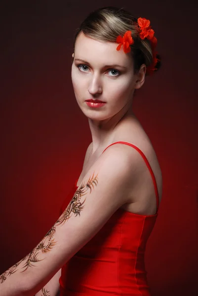 Luminoso modello fenicottero con fiori rossi nei capelli — Foto Stock