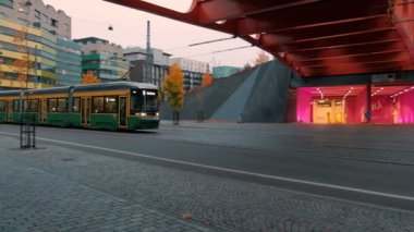 Helsinki, Finlandiya - 3 Ekim 2021: Modern Tram Jatkasaari mahallesindeki yaya köprüsünün altından geçiyor. Modern Avrupa İskandinav Mimarisi.