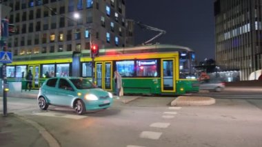 Helsinki, Finlandiya - 31 Ekim 2021: Günümüz Jatkasaari mahallesinde gece, tramvay ve arabalar trafik ışıklarından hareket ediyor.