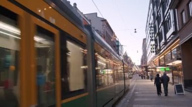 Helsinki, Finlandiya - 1 Aralık 2021: Aleksanterinkatu sokağı ve akşam üzeri Noel süslemeleri. Sokakta tramvaylar hareket ediyor.