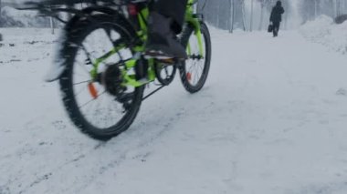 Kar fırtınası sırasında sokakta hareket eden bisikletçi..