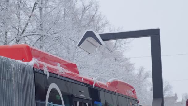 Der orangefarbene elektrische Stadtbus lädt. — Stockvideo