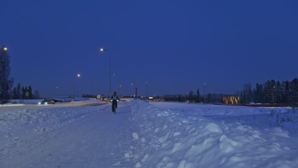 De man op de fiets op een winteravond. — Stockvideo