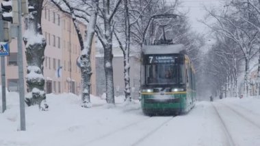 Helsinki tram on the street in winter during strong snowfall