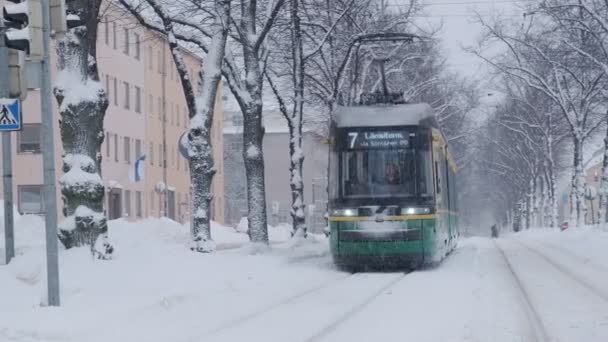 Helsingfors spårvagn på gatan på vintern under starkt snöfall — Stockvideo