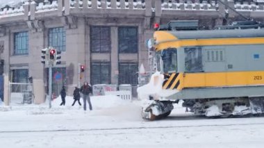 Tramvay kardaki rayları süpürüyor.