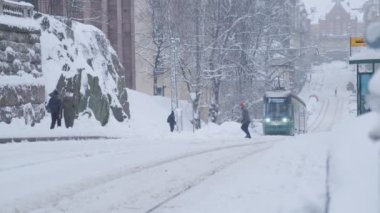 Helsinki tram on the street in winter during strong snowfall