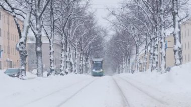 Helsinki tram on the street in winter during strong snowfall