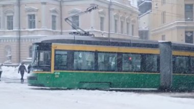 Helsinki tram on the street in winter during strong snowfall