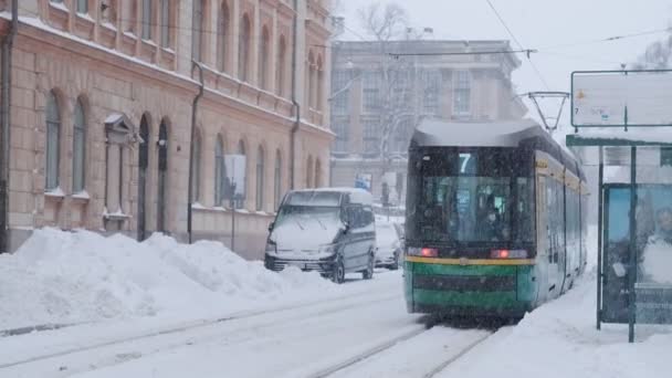 Helsingfors trikk på gaten om vinteren under kraftig snøfall. – stockvideo