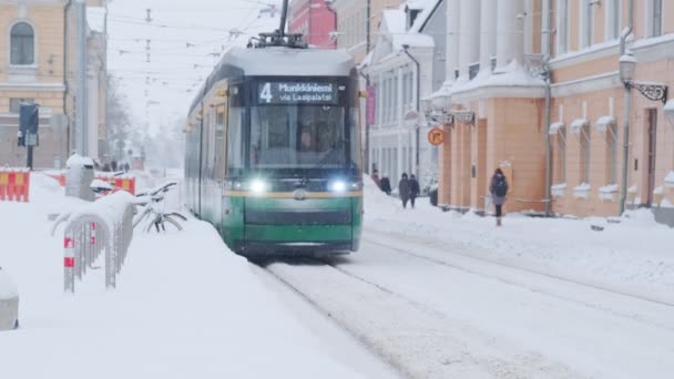 Helsinki tram on the street in winter during strong snowfall — Stockvideo