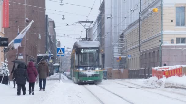 Helsinki tram on the street in winter during strong snowfall — Wideo stockowe
