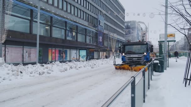 吹雪の間のヘルシンキ中央部のスカニア雪の耕運機 — ストック動画