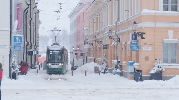 Helsingfors spårvagn på gatan på vintern under starkt snöfall — Stockvideo