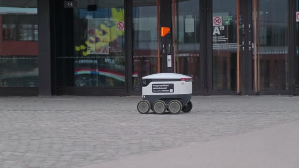 The Starship delivery robot is moving near The Aalto University, Espoo, Finland. — Stockvideo