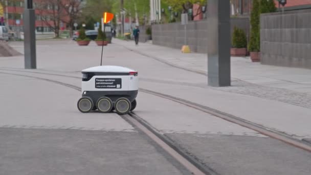 The Starship delivery robot is moving over the tram track in Finland. — Stockvideo