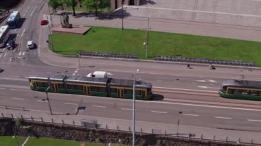 Helsinki, Finlandiya - 9 Haziran 2022: ForCity Smart Artic Helsinki tramvayı Finlandiya parlamentosundan geçiyor. Hava görüntüsü. Yavaş çekim, 0.5 hız