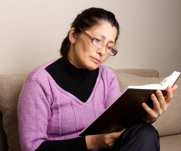 Mujer asiática leyendo un libro en casa. — Foto de Stock