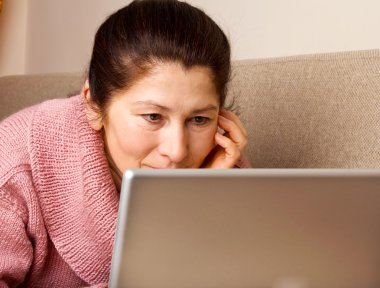 dizüstü bilgisayar, kanepede rahatlatıcı ile üst düzey kadın.