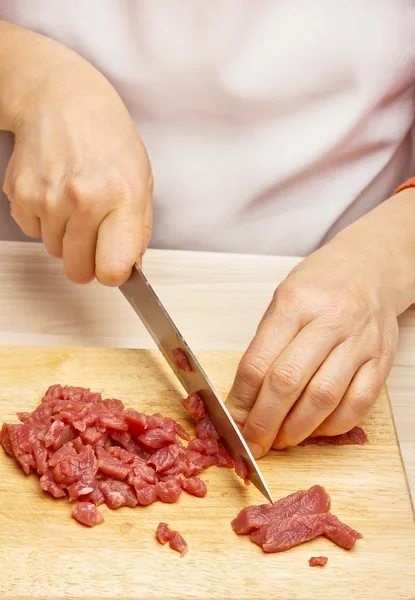 Närbild av kvinna händer styckning av nötkött på skärbräda. — Stockfoto