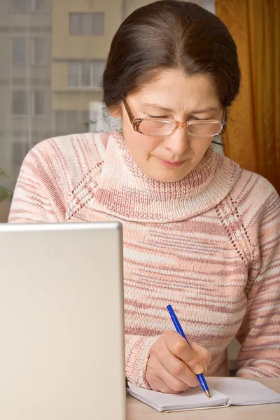 Старшая женщина с ноутбуком, расслабляется на диване . — стоковое фото