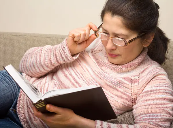 Seniorkvinne leser en bok – stockfoto